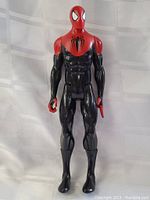 Full body front view of the Spiderman action figure showing black and red suit and spider emblem on chest.