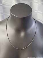 Sterling silver chain necklace displayed on a black mannequin bust, showing front and side angles to highlight chain details and length.