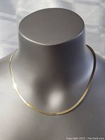 Front view of the sterling silver necklace displayed on a grey mannequin neck, showing the full 18-inch chain laying flat.