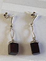 Front view of the pair of sterling silver earrings with cube-shaped black onyx pendants, showing overall design and condition.