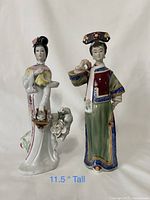 Photo showing both porcelain Asian figurines side by side against a white background, highlighting their detailed hand-painted features and colors.