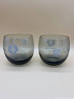 Two round whisky smoke glasses with New England Patriots and NFL logos photographed from front.