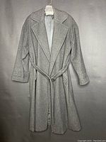 Gray wool trench coat on hanger with belt tie closure, wide lapels, and smooth lining