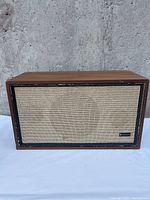 Front view of Criterion 50A speaker showing wooden enclosure and beige fabric grille with slight wear.