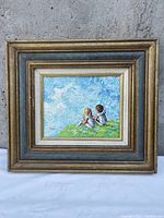 Full view of framed painting showing two children and textured blue sky background.