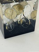 Close-up of one side of the acrylic block showing the embedded 1978 Lincoln pennies inside the paperweight