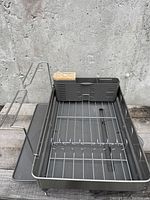 Full view of gray and stainless steel dishrack, showing wire rack and utensil holder with bamboo accent, on gray base with feet.