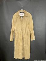 Front view of full tan trench coat on hanger showing overall condition and length.