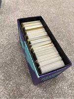 Top-down image of open Elite Trainer Box showing a large quantity of Pokémon cards inside, tightly packed and standing upright.