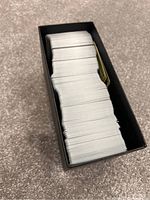 Top view showing large quantity of Pokémon cards inside black Elite Trainer Box.