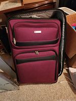 Exterior photo of the burgundy Airways luggage showing front zippered compartments.