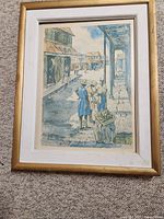 Front of framed watercolor painting showing West Indies street scene with two women in blue and market stall.