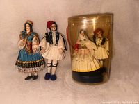 Two pairs of Greek inspired souvenir dolls, one pair loose and one pair in original labeled plastic packaging.