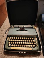 Front view of Smith Corona Super Sterling typewriter positioned inside open carrying case
