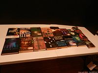 Photo of 17 assorted horror and suspense fiction books laid on a table showing front covers and spine titles.