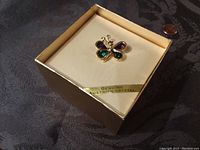 Butterfly brooch in original box showing size relative to penny; label 'Genuine Austrian Crystal' visible.
