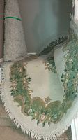 Photo of the full length of the wool oriental rug on stairs showing cream base with floral design and fringed edges.