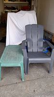 Photo of two plastic lawn chairs, one grey Adirondack style and one green small chair or table, showing their overall shape and condition.
