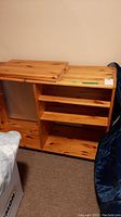Front view of wood shelving unit showing multiple adjustable shelves and natural wood finish.