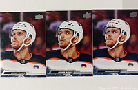 Photo showing three Connor McDavid hockey cards from Upper Deck brand, front view with player in hockey gear.