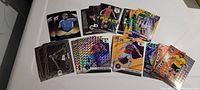 Top-down photo of 10 Premier League football/soccer trading cards laid out on a white surface showing different players, card designs, and holographic effects.