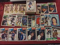 A layout of 24 O-Pee-Chee hockey cards featuring Winnipeg Jets players in various poses and card designs, laid out on a wooden surface.