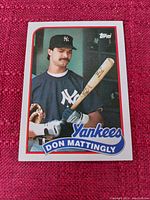 A baseball card showing Don Mattingly in New York Yankees gear, holding a bat with a white and red bordered card face, featuring team and player name in blue.