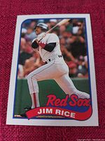 Single MLB baseball card featuring Jim Rice in Red Sox uniform mid-bat, encased by white border with blue frame.