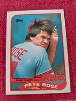 Front of Topps baseball card showing Pete Rose in Reds uniform with card branding and text.