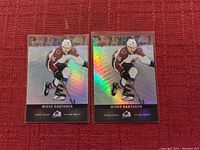 Two Upper Deck Mikko Rantanen Colorado Avalanche hockey cards displayed on a red background. Both cards have a holographic foil finish and feature Mikko Rantanen in action pose.