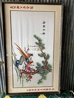 Full view of large framed embroidered silk art featuring colorful birds and floral branches with embroidered Asian characters on matting