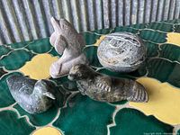 All four carved stone animal figures arranged for group view showing details and scale.