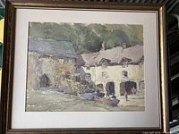 Full view of the framed watercolour painting showing village houses and boats.