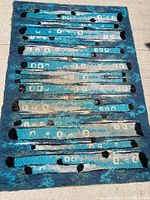 Full view of rectangular wool rug with abstract mid century modern design in blue and black tones on light background.