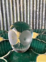 Front view of clear glass owl figure showing two large frosted circular eyes with etched pupil dots and internal feather-like pattern at the top.
