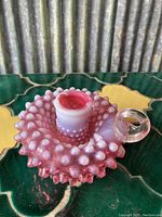 Pink Fenton hobnail glass candle holder showing side angle with hobnail texture and handle