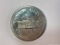 Reverse side of the coin showing Prince Edward Island building and inscriptions indicating the coin's commemorative period and theme.