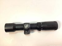 Side view of the black Excalibur Tact Zone crossbow scope showing the adjustment turret with logo and magnification control ring.