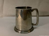 Full side view of the pewter stein showing cylindrical body, handle, and base.