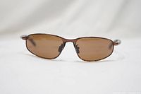 Close-up front view of vintage Serengeti sunglasses showing oval brown lenses and brown frame.