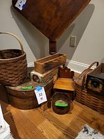 Overview of all items including two shaker boxes, cigar box, sewing machine drawer, woven baskets, and small wooden bench.