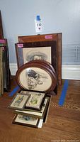 Stacked vintage Currier and Ives framed prints with different frame shapes and sizes.
