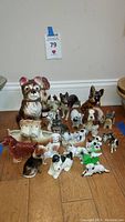 Front view of all vintage ceramic dog figurines arranged on floor, showing variety size and color