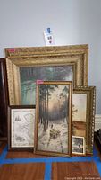 Group photo showing all four framed items: three artworks and one map, all with gold-toned frames.