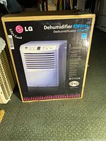Photo of LG dehumidifier in original box showing front side with model and features printed.