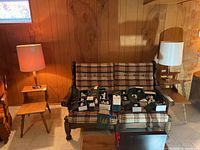 Two matching lamps placed on tables beside a plaid covered bench, showing overall size and style of the lamps.