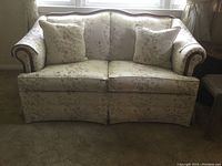 Full view of the Broyhill love seat showing floral patterned upholstery and rolled arms.