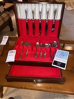Wooden chest open showing entire flatware set