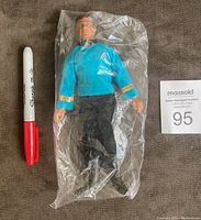 Front view of factory sealed Dr. Bones McCoy figure in original clear plastic bag next to a red Sharpie marker for scale.