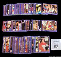 Partial set of 62 out of 99 Mork & Mindy trading cards displayed face up showing colorful character scenes and dialogues. Cards have purple borders and vintage printing style.